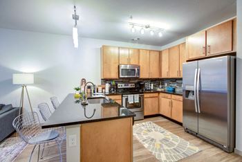 A kitchen with wooden cabinets and a black countertop.